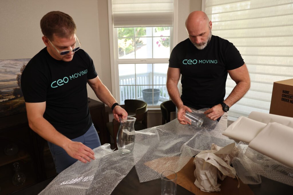 Professional packer wrapping household items in packing paper