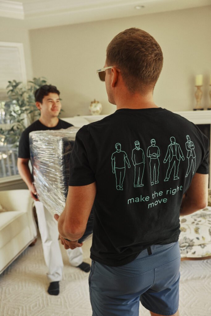 Mover carrying shrink-wrapped furniture during an apartment move