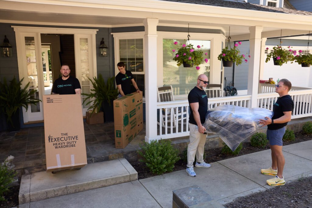 CEO Moving crew carrying wrapped furniture out the front door of a Bay Area home