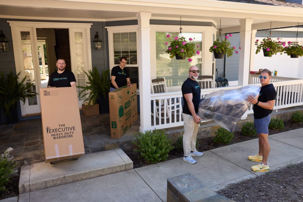 Movers bringing wrapped furniture through the front door of a suburban Bay Area home