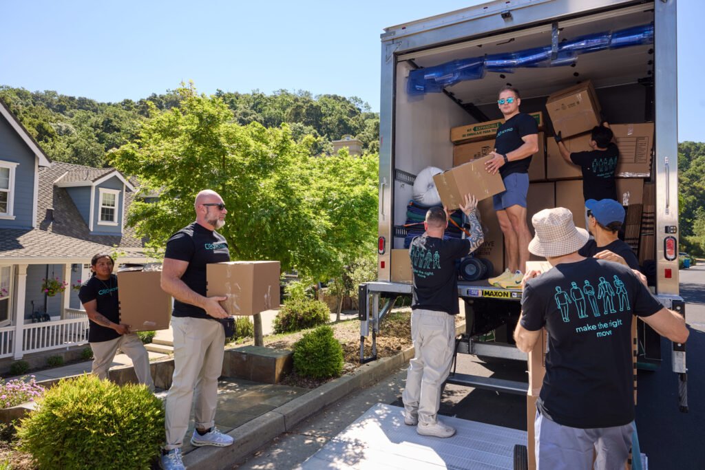 Movers loading boxes up the ramp into a moving truck
