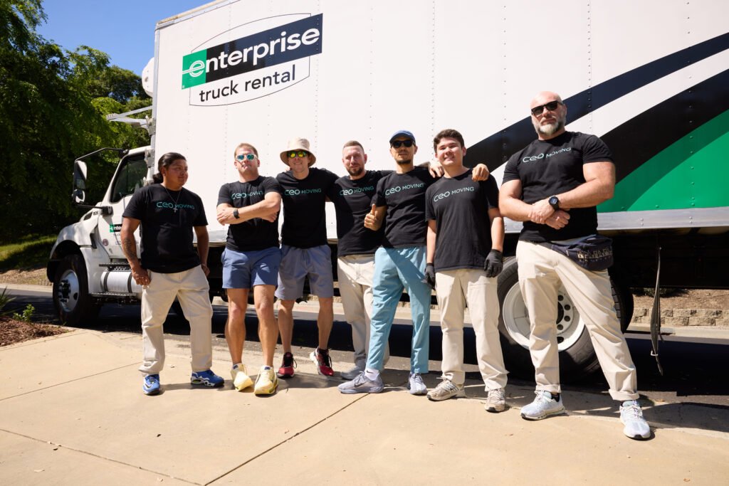 CEO Moving long-distance crew standing in front of their trucks