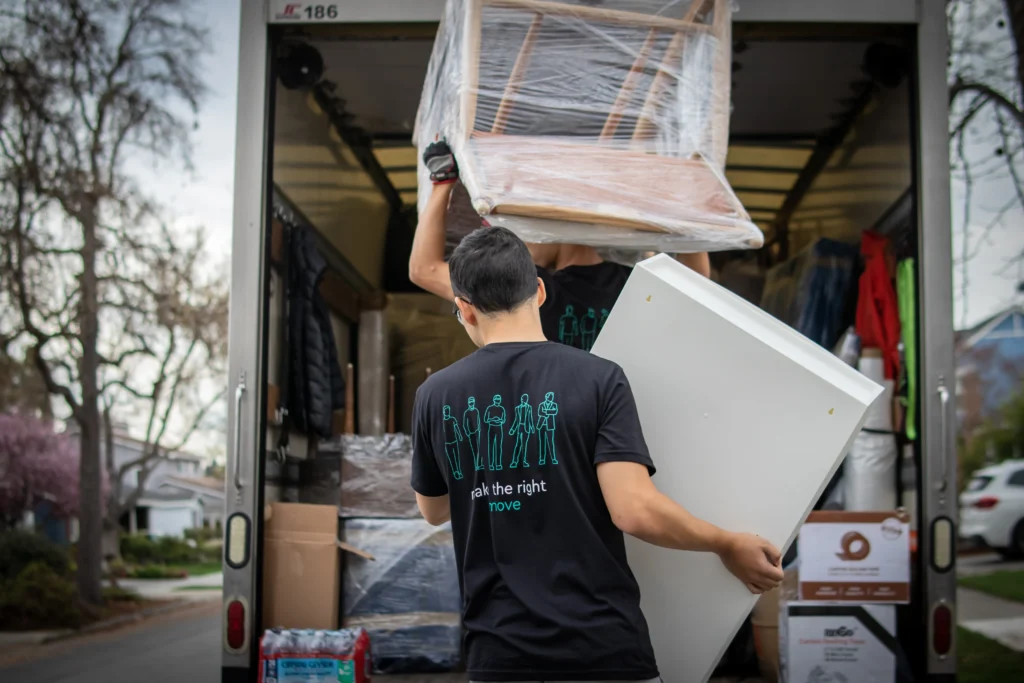Professional movers loading furniture into a moving truck during a Bay Area home move — change of address checklist