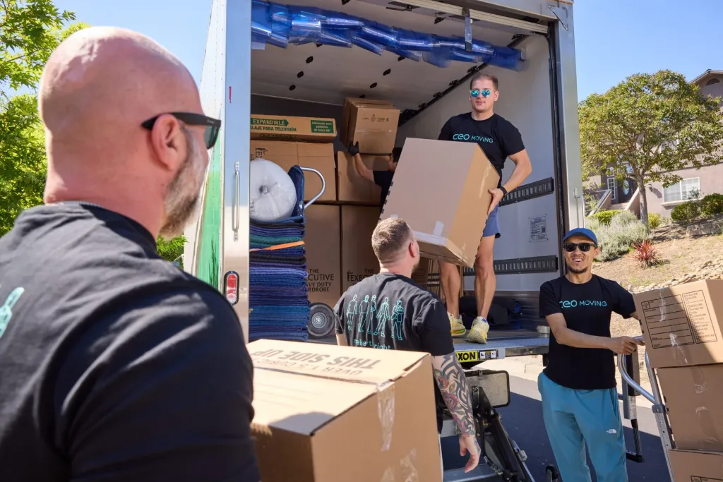CEO Moving crew loading boxes into the company's own moving truck, a sign of a legit moving company and not a fake one